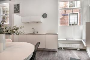 cocina blanca con mesa y ventana en Apartment Eewal 68, en Leeuwarden