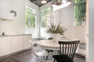 una cocina blanca con mesa y algunas sillas en Apartment Eewal 68, en Leeuwarden