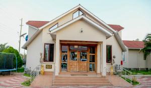 una piccola casa bianca con una porta in legno di Samanene Hotel a Mwanza