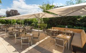 un ristorante con tavoli e sedie sotto un ombrellone di Hotel Oranien Wiesbaden a Wiesbaden