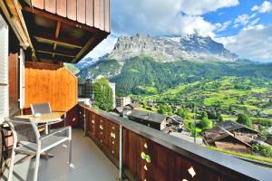 balkon ze stołem i widokiem na góry w obiekcie Studio Eigerblick w mieście Grindelwald