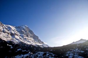 a snow covered mountain with a kite flying in the sky w obiekcie Studio Eigerblick w mieście Grindelwald