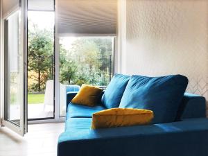 a blue couch with yellow pillows in a living room at Apartament 23 w Porto Łeba in Łeba