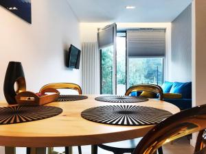 a dining room table with chairs and a wooden table at Apartament 23 w Porto Łeba in Łeba