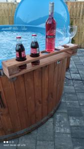 twee flessen coca cola op een houten tafel naast een zwembad bij Uroczy domek z baliá z jacuzzi in Władysławowo