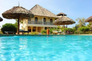 un complexe avec une piscine bordée de parasols dans l'établissement Marula Park, à Diani Beach