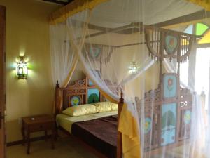 - une chambre avec un lit à baldaquin dans l'établissement Marula Park, à Diani Beach