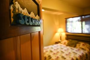 a small bedroom with a bed and a window at Auberge Kicking Horse Guest House in Golden