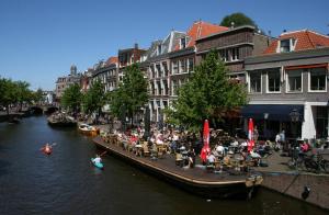 un grupo de personas sentadas en barcos en un río en Tulip Inn Leiden Centre, en Leiden