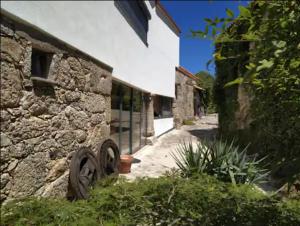 un edificio de piedra con algunas plantas delante de él en Quinta do Borges 2, en Guarda