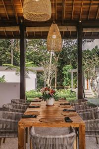 una mesa de madera con sillas de ratán y un asterisco en Umah Shama, en Ubud