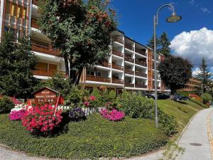 un jardín con flores frente a un edificio en Cozy central apartment at a special price!, en Crans-Montana