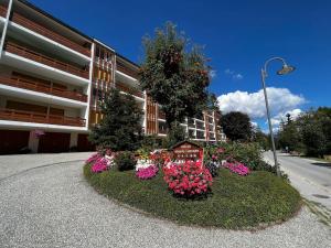 un círculo de flores frente a un edificio en Cozy central apartment at a special price!, en Crans-Montana