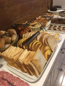 a buffet filled with different types of bread and pastries at Pousada Villa Vecchia in Canela