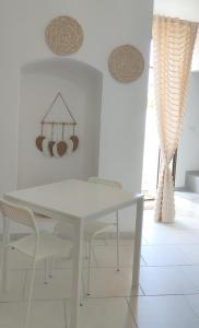 een witte eetkamer met een witte tafel en stoelen bij Appartamenti Boho Chic in Sannicandro di Bari