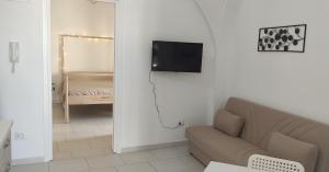 een woonkamer met een bank en een televisie aan de muur bij Appartamenti Boho Chic in Sannicandro di Bari