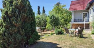 een vrouw aan een tafel in de achtertuin van een huis bij Ferienhaus am Rehberg in Eisenach