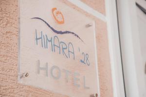 希马拉Himara 28 Hotel的墙上的标牌,上面有艾玛玛的标牌