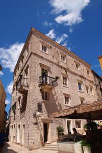 een groot stenen gebouw met een balkon bij Heritage Hotel Life Palace in Šibenik