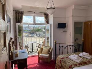 una camera con letto, tavolo e finestra di Harbour Hotel a Newquay