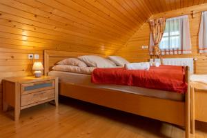 - une chambre avec un lit dans une cabane en bois dans l'établissement Chalet Ajda, à Bohinj