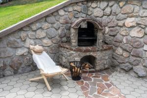 un mur en pierre avec une chaise et un four en briques dans l'établissement Chalet Ajda, à Bohinj