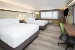 een hotelkamer met 2 bedden en een bureau bij Holiday Inn Express & Suites - Houston IAH - Beltway 8, an IHG Hotel in Houston