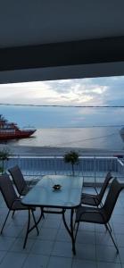 a table and chairs on a balcony with a view of the ocean at Elli's House in Keramotí