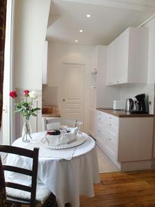 a kitchen with a table with a vase of flowers on it at Chambre d hôte : Louvre Elegant Apt Suite in Paris