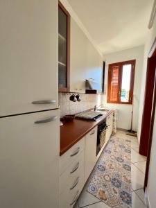 una cucina con frigorifero bianco e pavimento piastrellato di Summer Breeze Apartment - Avola ad Avola