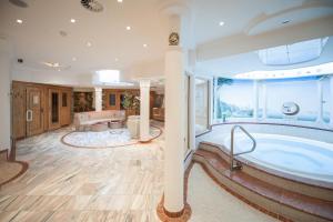 a large bathroom with a tub with a large window at Hotel Dornauhof in Finkenberg