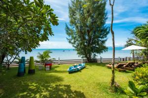 um quintal com vista para a água e uma praia em The Emerald Hill Beach Villa em Mae Nam