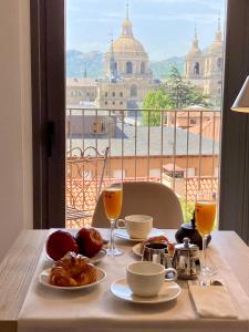 stolik z jedzeniem i napojami oraz widok na miasto w obiekcie San Lorenzo Suites w mieście San Lorenzo de El Escorial