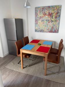 mesa de comedor con sillas y nevera en Ruhige Ferienwohnung, en Rostock