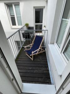 Un balcón con una silla azul y una mesa en Ruhige Ferienwohnung, en Rostock