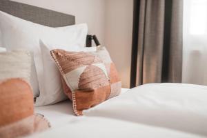 a bed with white sheets and pillows on it at apartments55 in Bressanone