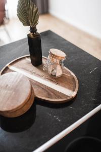 a wooden tray with a jar on a table with a plant at apartments55 in Bressanone