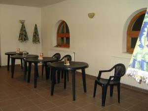 four black tables and chairs in a room at Szigeti B&B in Bogács