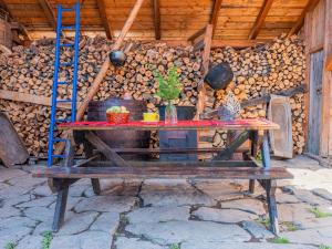 a picnic table in front of a wall of logs at Casa de vacanta traditionala romaneasca in Schiuleşti