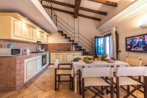 a kitchen with a table and chairs and a tv at Sardinia Home in Palau