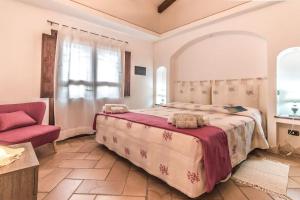 a bedroom with a large bed and a red chair at Sardinia Home in Palau