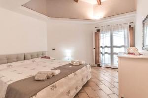 a bedroom with a large bed with towels on it at Sardinia Home in Palau