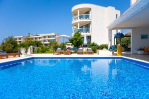 une piscine en face d'un bâtiment dans l'établissement Hotel Perla, à Rogoznica