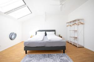 een slaapkamer met een bed in een witte kamer bij Ko-Living - Captain's Suite - Altstadt - mit Küche, Smart TV & Balkon - 6P in Halle an der Saale