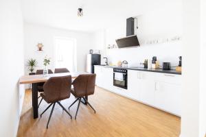 een keuken met een tafel en stoelen in een kamer bij Ko-Living - Captain's Suite - Altstadt - mit Küche, Smart TV & Balkon - 6P in Halle an der Saale