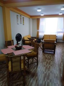 a living room with tables and chairs and a couch at ACOGEDOR DEPARTAMENTO in Coroico