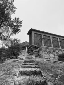 une photo en noir et blanc d'un chemin en pierre devant un bâtiment dans l'établissement Azenha do Tio Luís, à Caminha