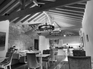 une salle à manger avec une table et des chaises ainsi qu'une cuisine dans l'établissement Azenha do Tio Luís, à Caminha