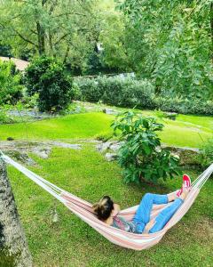 - une femme dans un hamac dans un jardin dans l'établissement Azenha do Tio Luís, à Caminha