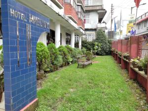 een bank in de tuin van een gebouw bij Hotel Mhelung in Darjeeling